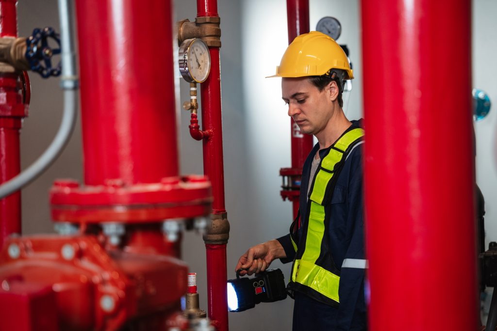 Engineers are inspecting the plumbing and water valves inside an industrial facility.